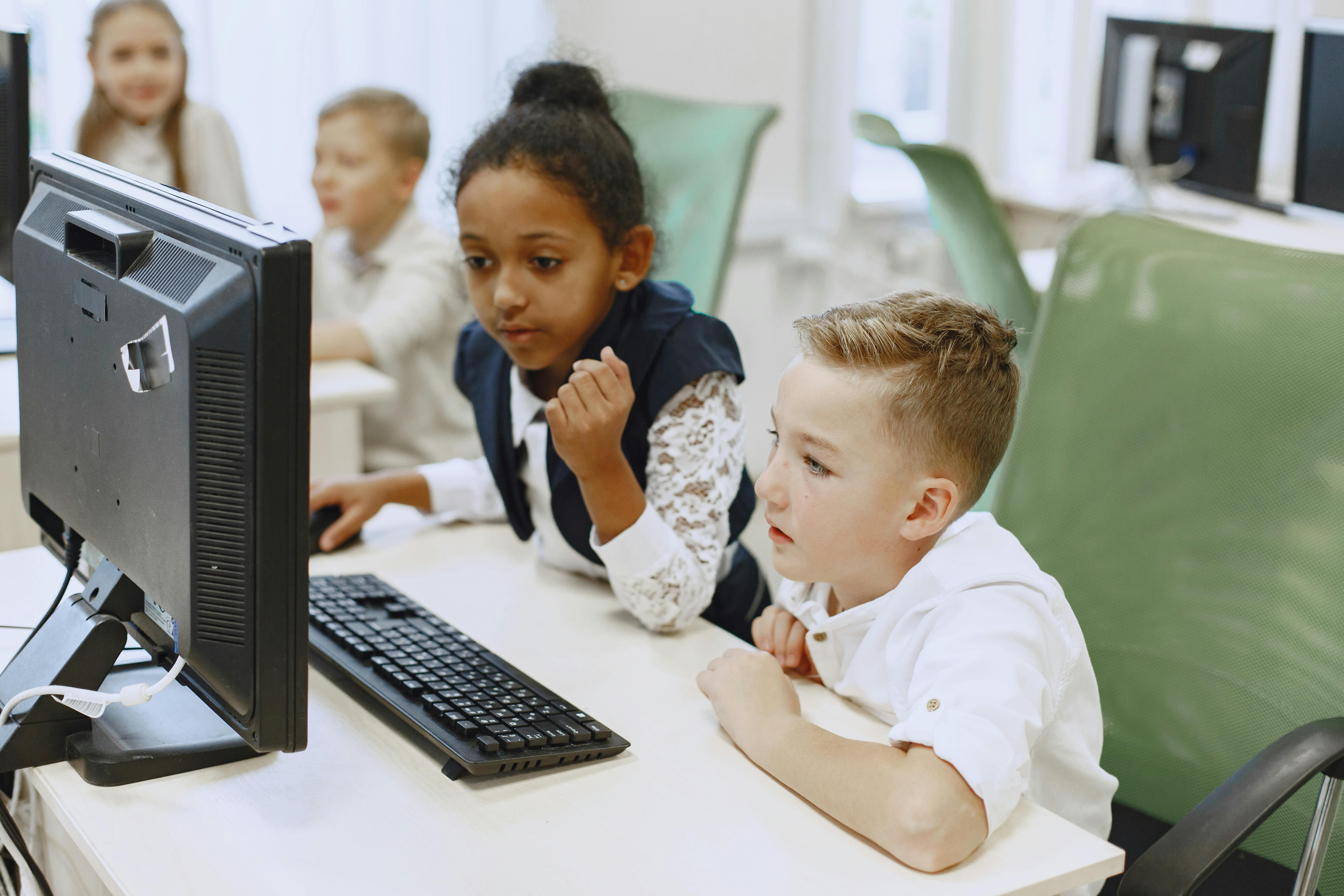 Kids using a computer while interacting.